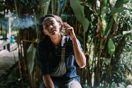 Téléchargez les photos : Un homme adulte brûle une cigarette - en image libre de droit