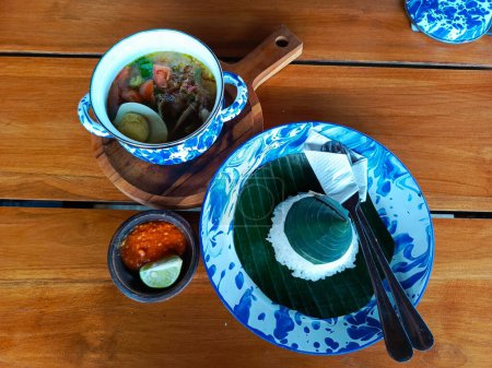 Soto Lamongan served in vintage tinware, evoking nostalgic village vibes, perfect for showcasing authentic Indonesian culinary heritage