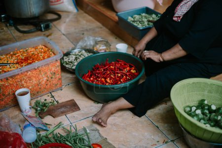 Eine Gruppe von Müttern kocht verschiedene Gerichte, um eine Menge zu bedienen