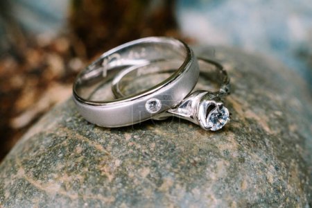 Photo for A wedding ring rests upon a smooth stone, embodying the enduring strength and stability of love, amidst the serenity of nature - Royalty Free Image