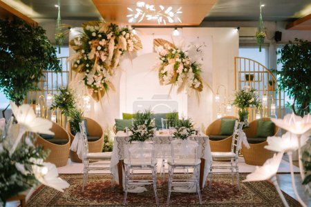 Eine wunderschön dekorierte Akad-Location mit Tisch, Stühlen und elegantem Hintergrunddekor. Ideal für Hochzeits-, Feier- oder Eventthemen in verschiedenen Marketing- oder redaktionellen Anwendungen