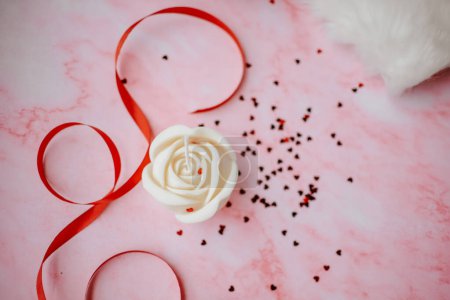 Téléchargez les photos : Mignonne bougie de cire de soja en forme de rose sur fond rose - en image libre de droit