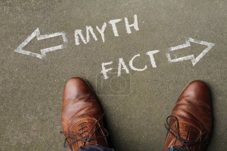 Man standing in front of two arrows and the words "Myth" and "Fact"