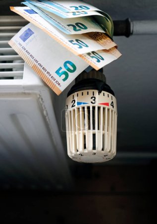 Foto de Control de los costes de calefacción - control del radiador y billetes en euros en la calefacción central - Imagen libre de derechos