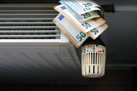 Foto de Control de los costes de calefacción - control del radiador y billetes en euros en la calefacción central - Imagen libre de derechos