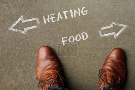 Person having to decide between Heating and Food - top view of the words and arrows pointing in opposite directions