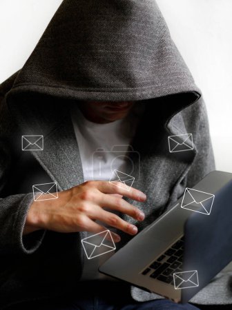 Spam mail and hacker holding laptop