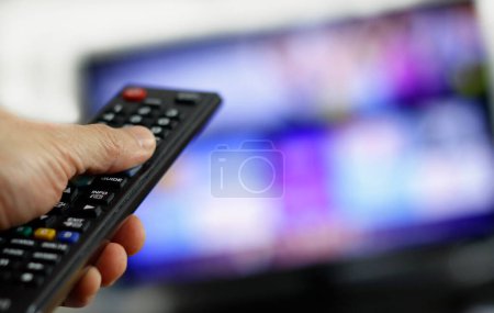 Photo for Remote control and screen - binge watching the favorite TV show - Royalty Free Image