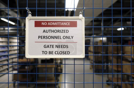 No admittance sign at a closed gate in a warehouse