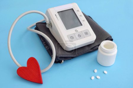 Tonometer zur Messung von Blutdruck und Tabletten, Herz auf blauem Hintergrund. Bluthochdruck, Weltherztag, Weltgesundheitstag