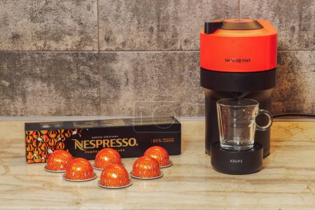 Photo for Thessaloniki, Greece - December 7 2022: Automatic Nespresso Vertuo Pop machine used to create espresso with aluminum capsules. Metal Pumpkin spice pods around Krups coffeemaker, for dripping coffee. - Royalty Free Image