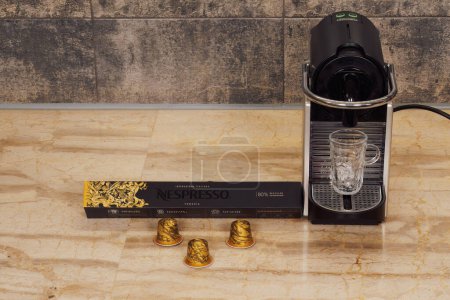 Photo for Thessaloniki, Greece - December 17 2022: Automatic Nespresso Original machine for espresso with aluminum capsules. DeLonghi coffeemaker for hot dripping coffee with metal Venezia pods. - Royalty Free Image