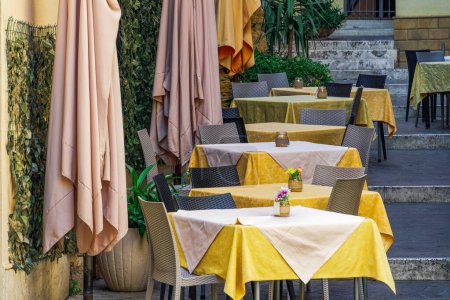 Restaurantsitzecke im Freien mit leeren Stühlen und Tischen in Agrigent, Italien.