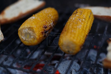 Téléchargez les photos : Cuisson de maïs sur l'épi sur le gril, à l'extérieur de la maison, pendant les vacances - en image libre de droit