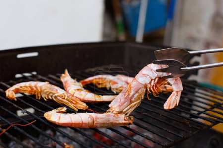 Téléchargez les photos : Grilled prawns on a homemade barbecue on a day off in a private home - en image libre de droit