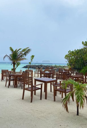 Tables with chair of a restaurant in a Maldivian island in the Indian Ocean