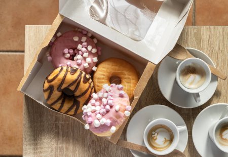 Top view of a breakfast or snack with donuts and coffee, doughnuts day.
