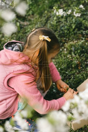 Foto de Búsqueda de carroñeros para niños en el parque. Chica aprendiendo sobre el medio ambiente. Actividad educativa natural para el Día Mundial de la Tierra. Explorando en primavera. - Imagen libre de derechos
