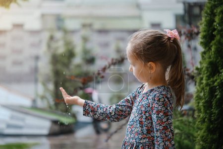 Téléchargez les photos : Les enfants attrapent des gouttes de pluie, concept météo. pluie tombant dans les mains des filles - en image libre de droit
