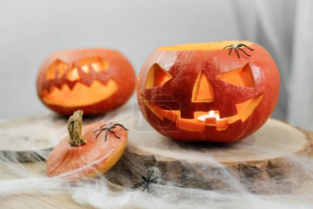 Téléchargez les photos : Citrouilles courbes Halloween sur la table décorée avec toile d'araignée. Lumière pour l'holoday à la maison - en image libre de droit
