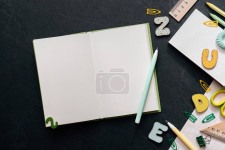Photo for Study, education, learning at school concept on black background with notebook copy space. Working table for creative writing, Trendy flat lay with pencils, alphabet, note blank, scheduler, planner - Royalty Free Image