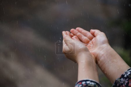 Téléchargez les photos : Les enfants attrapent des gouttes de pluie, concept météo. Gros plan de pluie tombant entre les mains - en image libre de droit