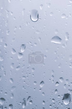 Téléchargez les photos : Des gouttes de pluie sur la fenêtre. De l'eau tombe sur le verre. fond naturel, fraîcheur. Temps froid et pluvieux. Gros plan. - en image libre de droit