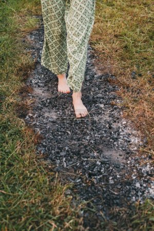 Foto de Carbón caminando o fuego caminando. Persona descalza sobre madera quemada y brasas calientes. Fuerza de voluntad y fuerza de entrenamiento para la curación. iniciación y fe - Imagen libre de derechos