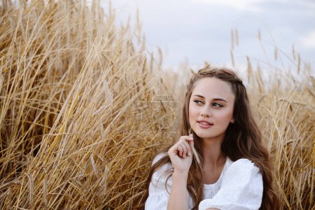 Téléchargez les photos : Belle femme sur le champ de blé. Jeune femme avec maquillage portrait de beauté à l'extérieur. Terres agricoles ukrainiennes avec seigle. Boho style chic. - en image libre de droit