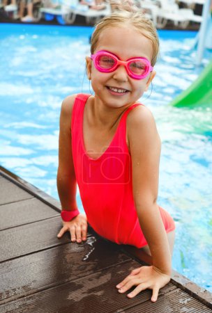 Téléchargez les photos : Enfant heureux dans la piscine extérieure. Fille préscolaire profitant de la baignade d'été. Enfant s'amusant près de l'eau, activités pour le repos et la santé en vacances Au bord de la piscine. Se préparer à plonger - en image libre de droit