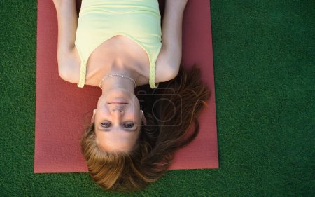Téléchargez les photos : Femme relaxante dans la pose de shavasana après la pratique du yoga. Soins de santé préventifs pour adultes. Pleine conscience. Mère et fille posant sur des nattes - en image libre de droit