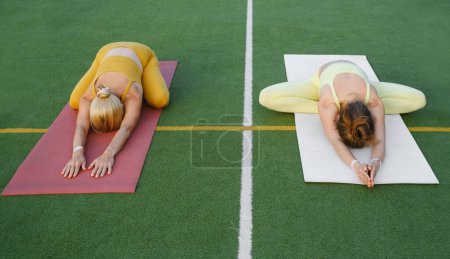 Foto de Dos mujeres haciendo yoga al aire libre Madre e hija adulta practicando juntas. Madura femenina y joven que tiene actividades de atención plena. Familia Estilo de vida activo, entrenamiento en montañas - Imagen libre de derechos
