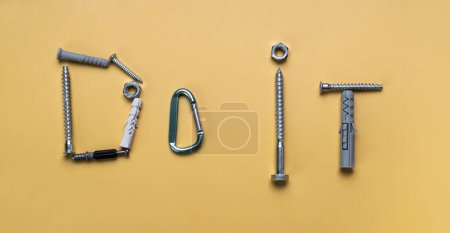 Photo for Sign Do it, frame with copy space made of bolts, screws. Banner on yellow plain background - Royalty Free Image