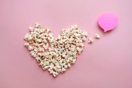 Photo for Pop Corn heart on pink background. Valentines day present cinema concept. Top view flat lay with copy space. Place for idea, quote or film title - Royalty Free Image