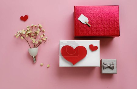 Téléchargez les photos : Idée cadeau Saint-Valentin, carte créative romantique plat avec espace de copie sur rose. Petites fleurs en forme de bulbe. Petites et grandes boîtes, forme dure. Plat vue de dessus - en image libre de droit