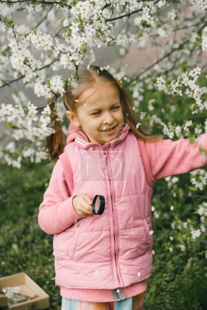 Photo for Scavenger hunt for kid in the park. Girl learning about environment. Natural education activity for World Earth day. Exploring in spring. - Royalty Free Image