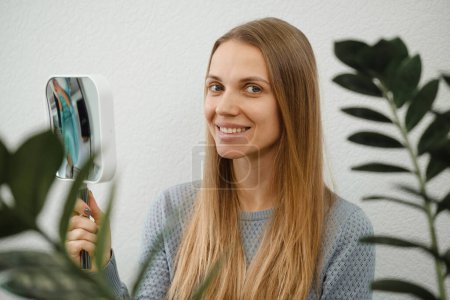 Photo for Client checking dermatology treatment result, skin face problems and therapy methods. Woman happy after skincare. Customer in beauty salon with mirror - Royalty Free Image