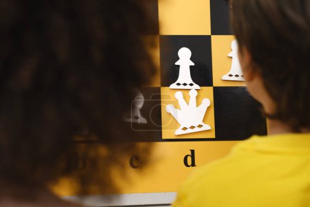Téléchargez les photos : Gros plan de la reine Enfant Penser dur sur les combinaisons d'échecs sur le tournoi pour les enfants Jeu intellectuel, passe-temps pour les enfants - en image libre de droit