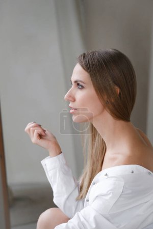 Photo for Pretty gentle Caucasian woman happy in white shirt. Daring fashion style portrait of decisive sensual female. Confident relaxed free girl, sunny morning room. Freshness, beauty, natural skin - Royalty Free Image