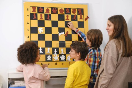 Téléchargez les photos : Child Thinking Hard On Chess Combinaisons sur le mur sur le tournoi pour les enfants Jeu intellectuel, passe-temps pour les enfants - en image libre de droit