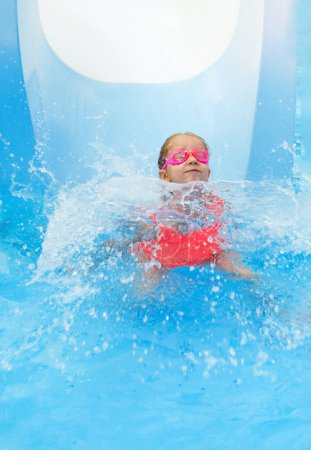 Photo for Happy child in outdoor swimming pool. Preschool girl enjoying summer time swimming. Kid having fun sliding down, activities for rest and health on vacations On the edge of pool. Getting ready to dive - Royalty Free Image