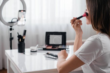 Weibliche Schönheit Blogger Aufnahme Vlog Video auf dem Smartphone At Home Online Makeup von der Rückseite. Streaming, Kopierraum