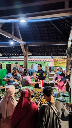 Foto de Imágenes desenfocadas, borrosas y ruidosas de las actividades de la gente desayunando en el mercado tradicional de Ngasem, Yogyakarta - Imagen libre de derechos