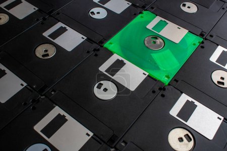 Téléchargez les photos : Une disquette verte se trouve dans une pile de vieilles disquettes - en image libre de droit