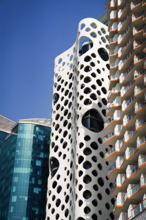 Téléchargez les photos : Gros plan à haute résolution de la tour de fromage Cheddar, bâtiment O-14 à Business Bay, Dubaï, avec fond bleu ciel, montrant les légères courbes du bâtiment et la façade en verre. - en image libre de droit