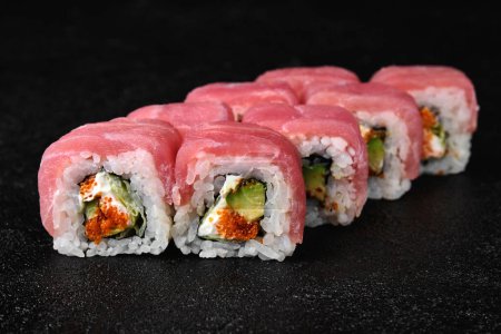 Photo for Tuna sushi roll with caviar on black concrete background - Royalty Free Image
