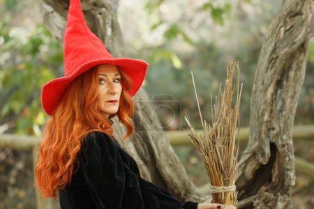 Photo for Redhead witch with red hat and broom looking at camera in the preventory of Alcoi, Spain - Royalty Free Image
