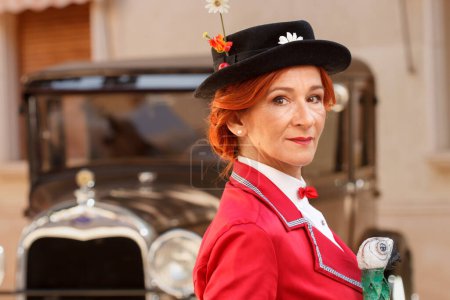 Téléchargez les photos : Femme habillée en Mary Poppins avec bokeh de voiture rétro à la foire moderniste Novelda 2023 - en image libre de droit