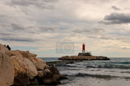 Photo for Beautiful maritime sunset with lighthouse at the entrance to the fishing port of Villajoyosa, Spain - Royalty Free Image