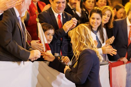 Foto de Alcoy, España, 19-04-2024: Directora del himno del festival Alcoy Blanca Carbonell recibiendo la batuta del niño que representará a San Jorge en las festividades. Acto libre y callejero. - Imagen libre de derechos
